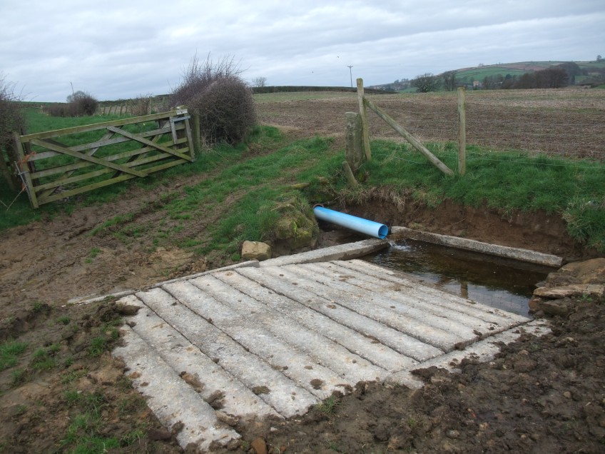 This watering point was improved by creating an area of hardstanding using concrete sleepers. The water quality will now be improved for river species and also for the farm livestock. Copyright NYMNPA.